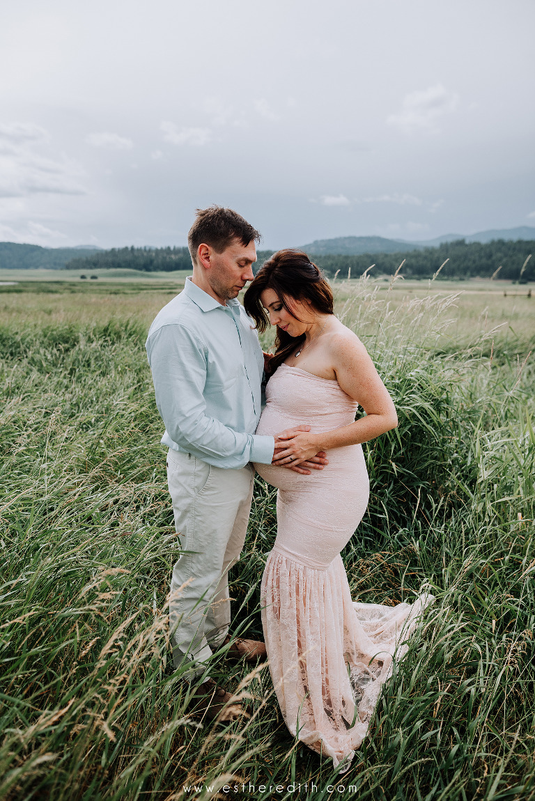 couple maternity pictures in green field, summer maternity session, cloudy maternity pictures